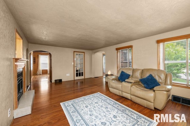 824 S State St, Geneseo, IL 61254 - living room with arched walkways, wood finished floors, a textured ceiling, and a glass covered fireplace