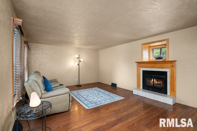 824 S State St, Geneseo, IL 61254 - living room featuring wood finished floors, a fireplace, and a textured ceiling