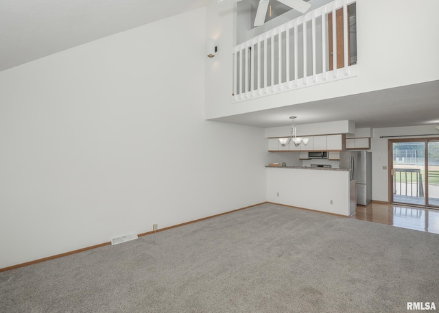 2112 35th St Unit 3, Rock Island, IL 61201 - unfurnished living room featuring carpet floors, a chandelier, baseboards, and a high ceiling