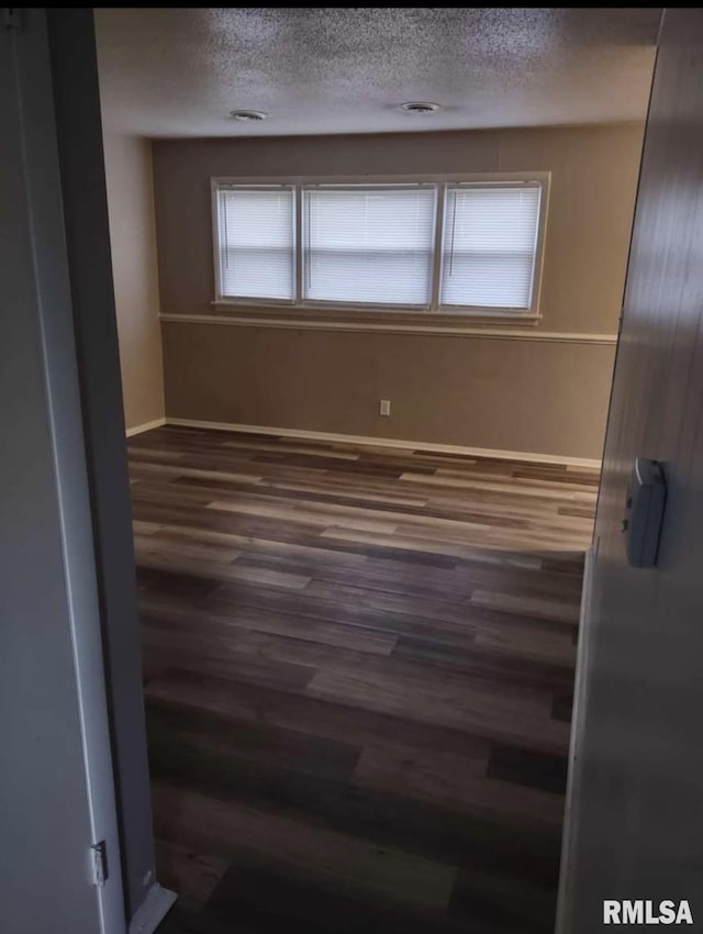2705 N Lincoln Ave, Davenport, IA 52804 - spare room featuring wood finished floors, a textured ceiling, and baseboards