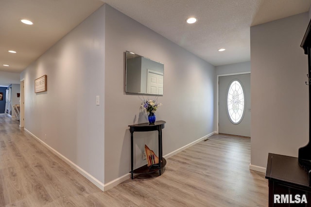 foyer featuring light wood-style floors, recessed lighting, and baseboards