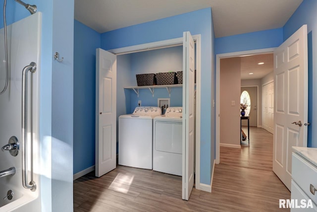 laundry room featuring separate washer and dryer, light wood finished floors, and baseboards