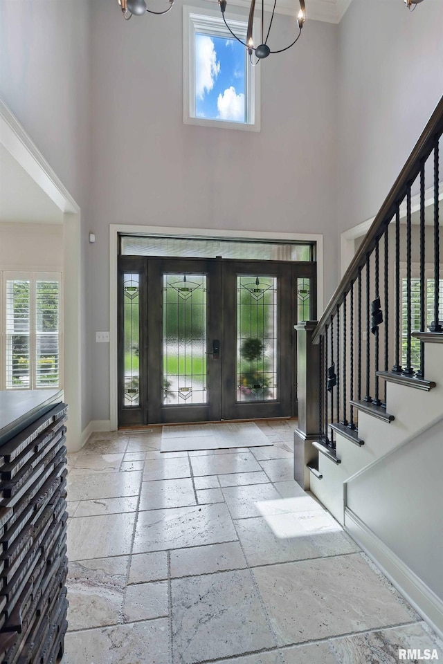 6531 Eagle Ridge Rd, Bettendorf, IA 52722 - foyer featuring a high ceiling, stone tile floors, a chandelier, french doors, and stairway