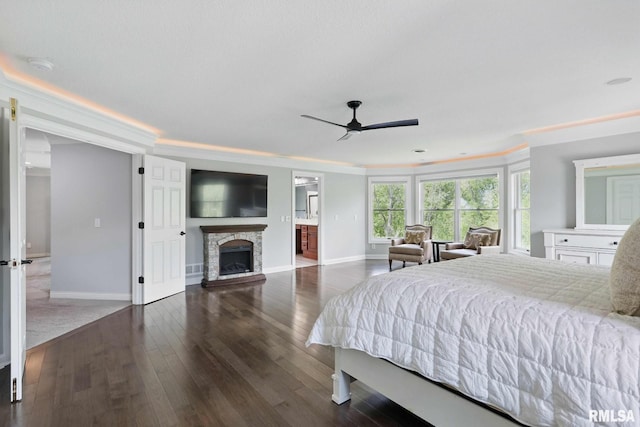 6531 Eagle Ridge Rd, Bettendorf, IA 52722 - bedroom with baseboards, a stone fireplace, wood-type flooring, crown molding, and a ceiling fan