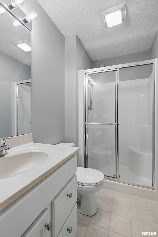 6531 Eagle Ridge Rd, Bettendorf, IA 52722 - full bathroom featuring vanity, tile patterned floors, a shower stall, toilet, and a textured ceiling