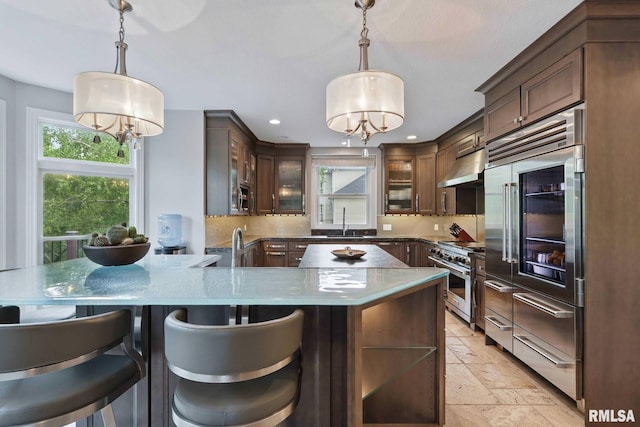 6531 Eagle Ridge Rd, Bettendorf, IA 52722 - kitchen with premium appliances, under cabinet range hood, recessed lighting, stone tile flooring, and a sink