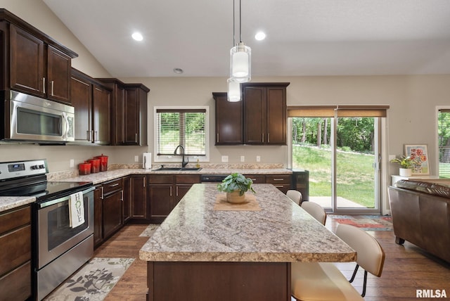 11 Musket Ct, Le Claire, IA 52753 - kitchen with appliances with stainless steel finishes, a sink, wood finished floors, a breakfast bar, and dark brown cabinets