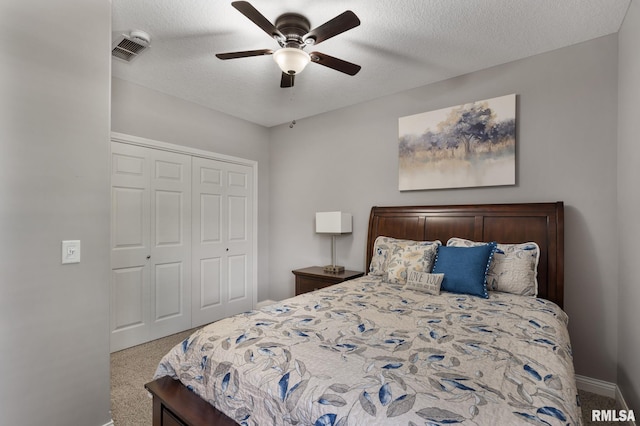 11 Musket Ct, Le Claire, IA 52753 - carpeted bedroom featuring a closet, a ceiling fan, baseboards, and a textured ceiling