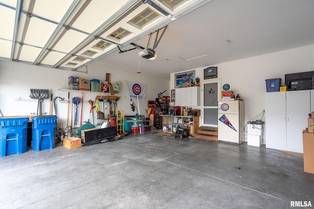 11 Musket Ct, Le Claire, IA 52753 - garage with a garage door opener and freestanding refrigerator