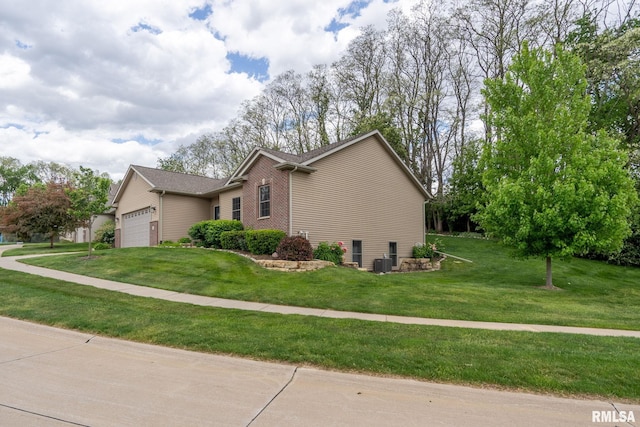 11 Musket Ct, Le Claire, IA 52753 - view of home's exterior featuring a garage, a lawn, and central air condition unit
