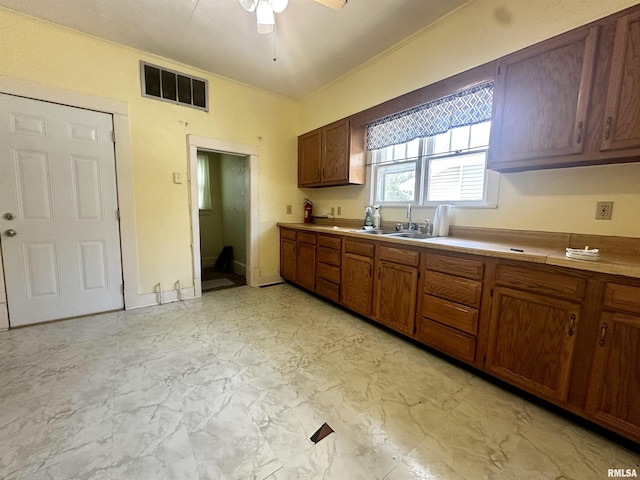 2213 Locust St, Eldorado, IL 62930 - kitchen with a sink, ceiling fan, light marble finish floors, light countertops, and crown molding
