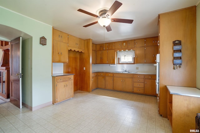 2006 Dixwell St, Davenport, IA 52802 - kitchen featuring ceiling fan, light floors, brown cabinets, light countertops, and a sink