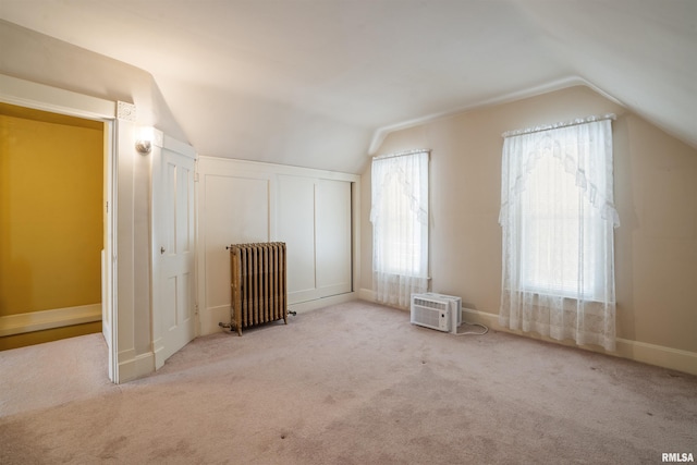 2006 Dixwell St, Davenport, IA 52802 - unfurnished bedroom featuring radiator heating unit, vaulted ceiling, carpet flooring, and a wall mounted air conditioner