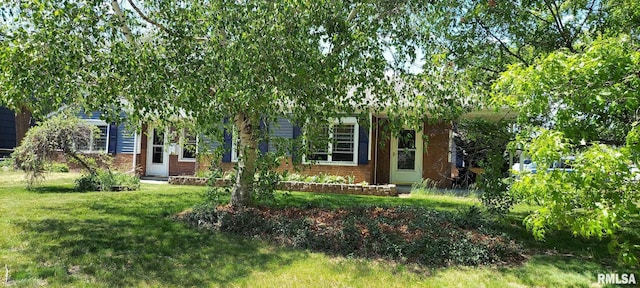 601 E St S, Kewanee, IL 61443 - view of property hidden behind natural elements with a front yard and brick siding