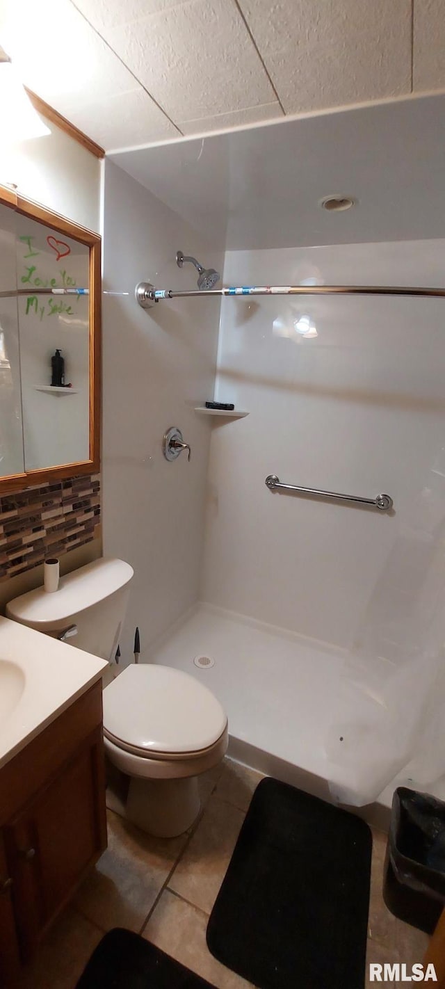 601 E St S, Kewanee, IL 61443 - full bath featuring backsplash, vanity, toilet, tile patterned flooring, and a shower