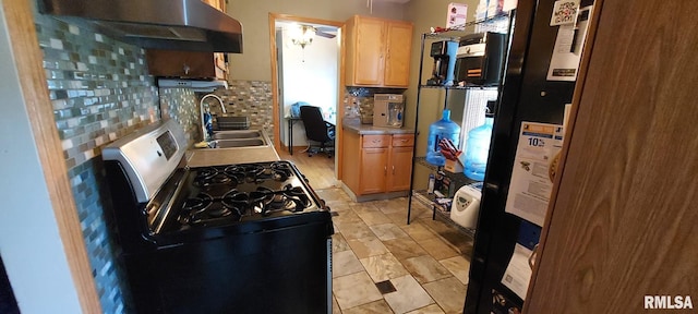 601 E St S, Kewanee, IL 61443 - kitchen with gas range, a sink, under cabinet range hood, backsplash, and light brown cabinetry