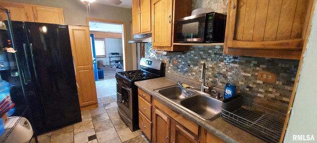 601 E St S, Kewanee, IL 61443 - kitchen featuring gas stove, black refrigerator with ice dispenser, a sink, under cabinet range hood, and tasteful backsplash