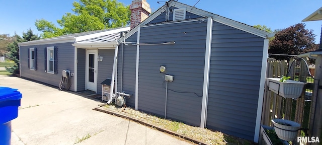 601 E St S, Kewanee, IL 61443 - view of side of home with fence, a patio, and a chimney