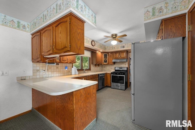 5117 Woodland Ave, Davenport, IA 52807 - kitchen with appliances with stainless steel finishes, a peninsula, a ceiling fan, brown cabinetry, and light countertops