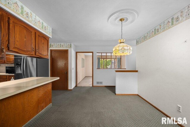 5117 Woodland Ave, Davenport, IA 52807 - kitchen featuring fridge with ice dispenser, light countertops, baseboards, brown cabinetry, and dark carpet