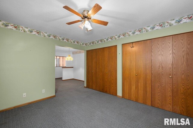 5117 Woodland Ave, Davenport, IA 52807 - unfurnished bedroom featuring carpet floors, two closets, baseboards, and a ceiling fan