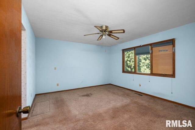 5117 Woodland Ave, Davenport, IA 52807 - spare room featuring carpet floors, baseboards, and ceiling fan