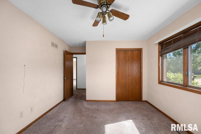 5117 Woodland Ave, Davenport, IA 52807 - unfurnished bedroom featuring carpet, baseboards, a closet, and a ceiling fan