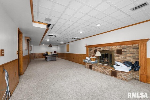 5117 Woodland Ave, Davenport, IA 52807 - carpeted living area featuring a wainscoted wall, wooden walls, and a brick fireplace