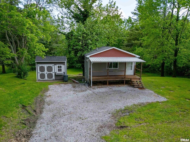 view of front of house featuring a front yard, a storage shed, an outdoor structure, and a porch