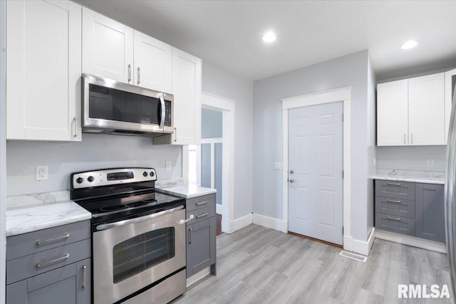 1720 Davie St, Davenport, IA 52804 - kitchen with appliances with stainless steel finishes, gray cabinetry, light wood-style flooring, baseboards, and recessed lighting