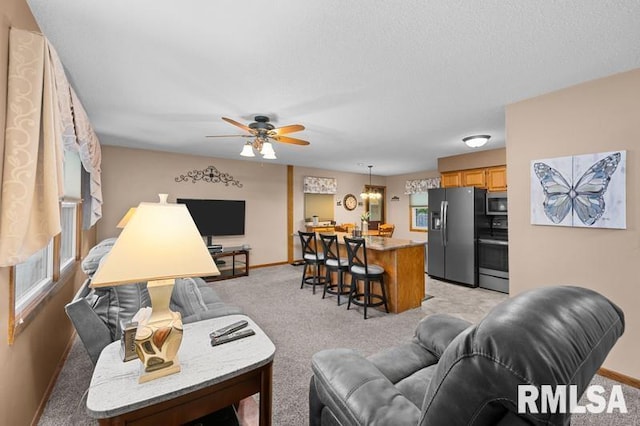 1005 17th St, Port Byron, IL 61275 - living area with light colored carpet, baseboards, and a ceiling fan