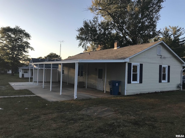 107 E Vermont St, Cambria, IL 62918 - rear view of house with a lawn, a chimney, a carport, and a patio area
