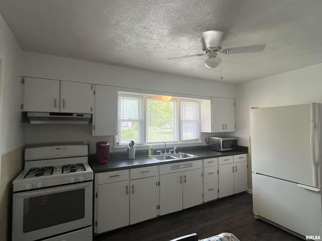 107 E Vermont St, Cambria, IL 62918 - kitchen with white appliances, under cabinet range hood, a sink, dark countertops, and a textured ceiling
