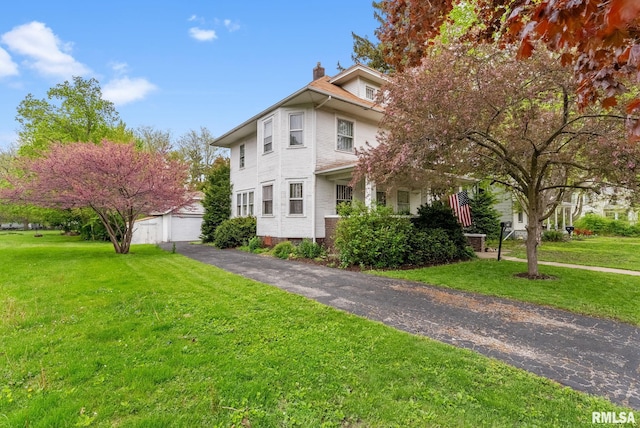 314 W Locust St, Cambridge, IL 61238 - view of front of house with a chimney, a front lawn, a detached garage, and an outdoor structure