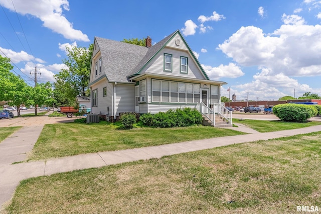 110 NW 3rd Ave, Aledo, IL 61231 - view of front of property with roof with shingles, a front yard, a chimney, cooling unit, and central air condition unit