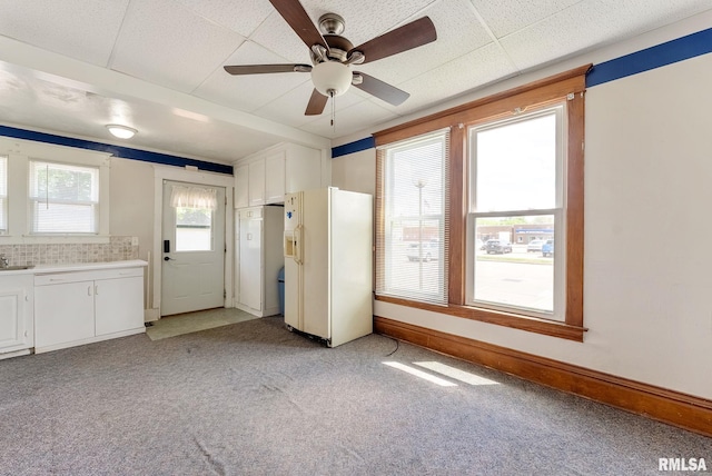 110 NW 3rd Ave, Aledo, IL 61231 - kitchen with white refrigerator with ice dispenser, light colored carpet, a ceiling fan, white cabinets, and light countertops