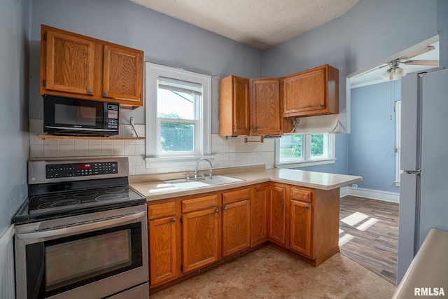 2721 11th Ave Unit B, Moline, IL 61265 - kitchen featuring black microwave, stainless steel electric stove, freestanding refrigerator, a sink, and light countertops