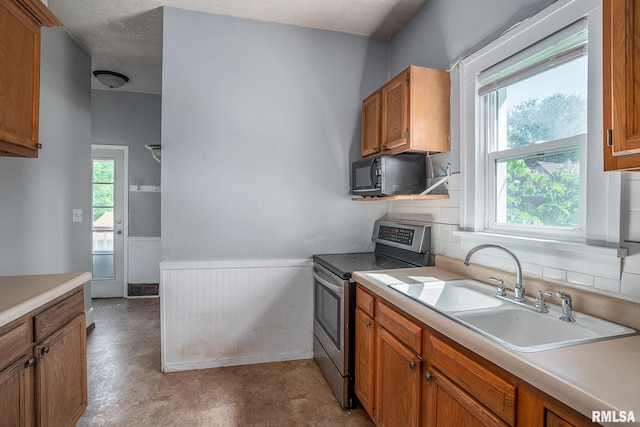2721 11th Ave Unit B, Moline, IL 61265 - kitchen featuring stainless steel electric range oven, black microwave, a sink, wainscoting, and light countertops