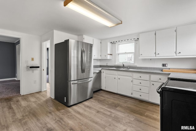706 8th St, De Witt, IA 52742 - kitchen featuring appliances with stainless steel finishes, a sink, light wood-style floors, and white cabinets