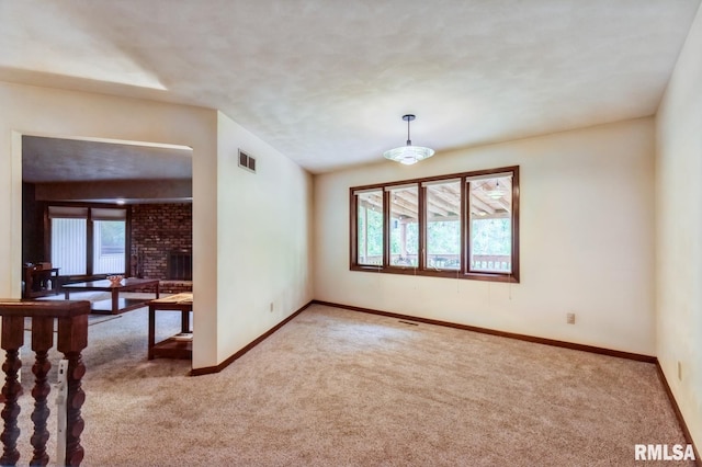 28009 230th St, Le Claire, IA 52753 - unfurnished room featuring carpet, baseboards, and a brick fireplace