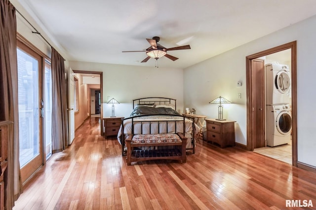 28009 230th St, Le Claire, IA 52753 - bedroom featuring stacked washing machine and dryer, light wood-style flooring, and baseboards
