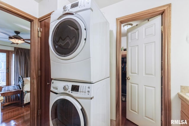 28009 230th St, Le Claire, IA 52753 - washroom featuring stacked washer and clothes dryer, ceiling fan, and wood finished floors