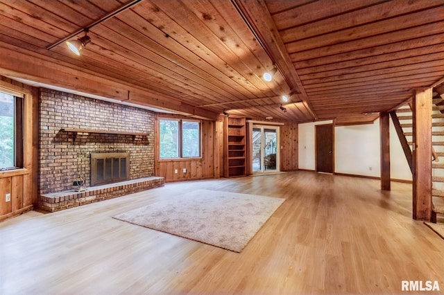 28009 230th St, Le Claire, IA 52753 - unfurnished living room with wood ceiling, wood finished floors, stairway, a brick fireplace, and baseboards