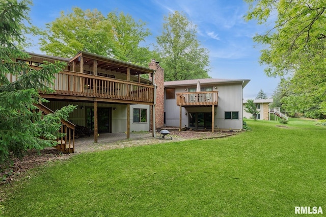 28009 230th St, Le Claire, IA 52753 - rear view of house with a chimney, a yard, a wooden deck, and a patio area