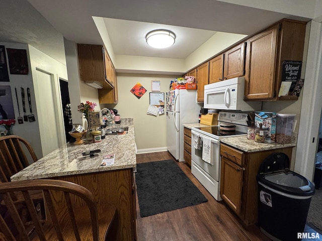 3143 4th St Unit 3143, Moline, IL 61265 - kitchen with white appliances, a sink, dark wood-style floors, brown cabinets, and light stone counters