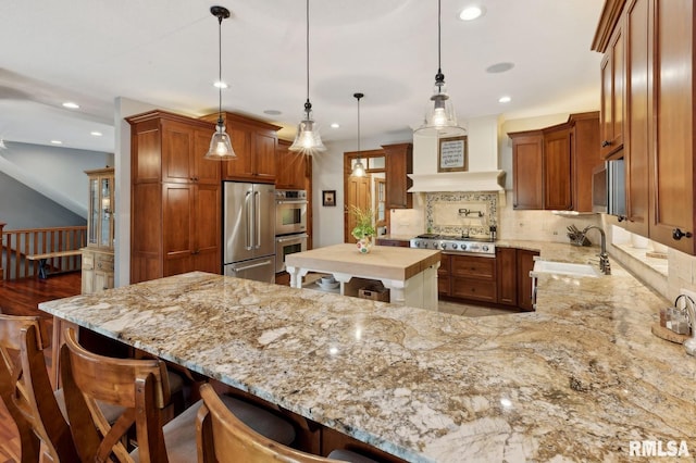 27998 229th St, Le Claire, IA 52753 - kitchen featuring a sink, appliances with stainless steel finishes, a kitchen breakfast bar, recessed lighting, and decorative backsplash