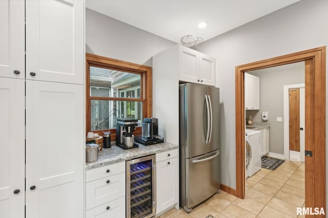 27998 229th St, Le Claire, IA 52753 - kitchen featuring freestanding refrigerator, wine cooler, washer / dryer, white cabinets, and light tile patterned floors