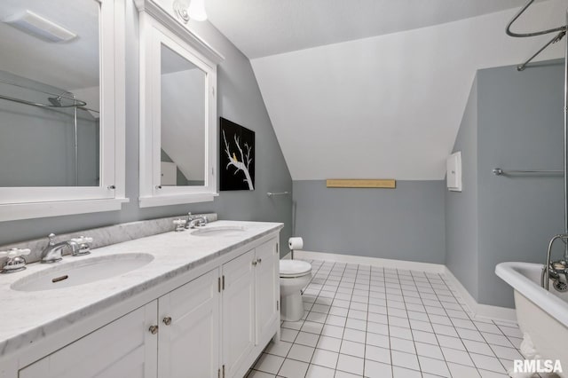 27998 229th St, Le Claire, IA 52753 - bathroom with lofted ceiling, toilet, tile patterned floors, double vanity, and baseboards