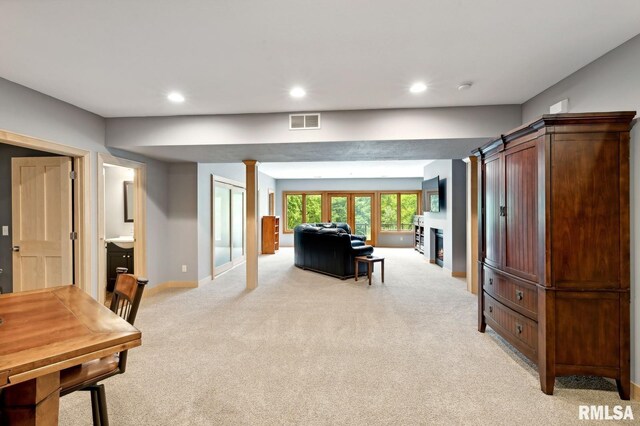 27998 229th St, Le Claire, IA 52753 - living area featuring light colored carpet, recessed lighting, baseboards, and a warm lit fireplace