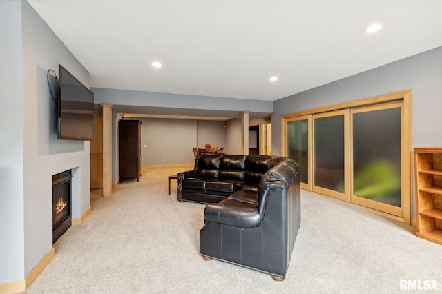 27998 229th St, Le Claire, IA 52753 - living area featuring light colored carpet, recessed lighting, a glass covered fireplace, and baseboards